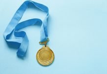 An Indian-Origin Nurse Honored With President Award In Singapore Gold Medal with Ribbon.